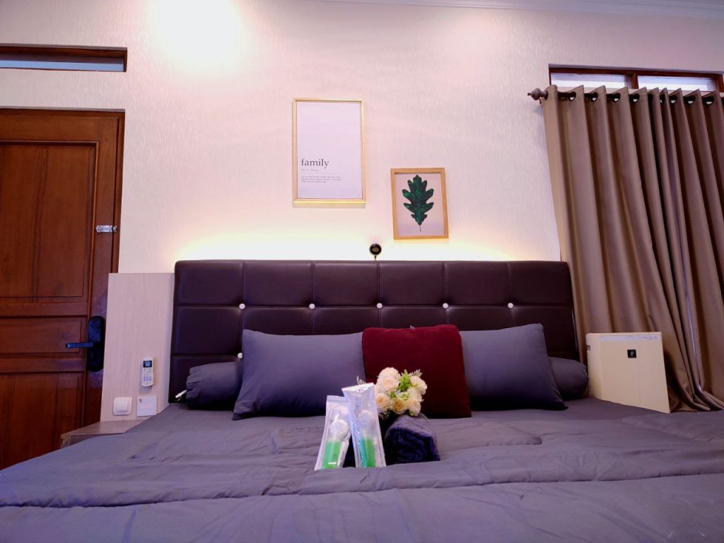 Kamar tidur utama di Family Suite Room Paps Suite House Yogyakarta dengan kasur king size dan interior modern.